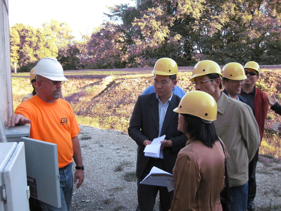 A group in yellow hard hats beside an electrical cabinet