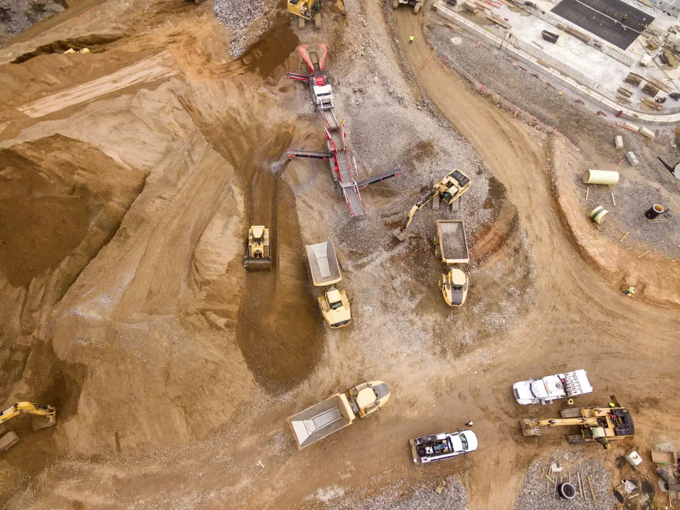 Trucks and earthmoving plant on a large earthworks site, seen from above